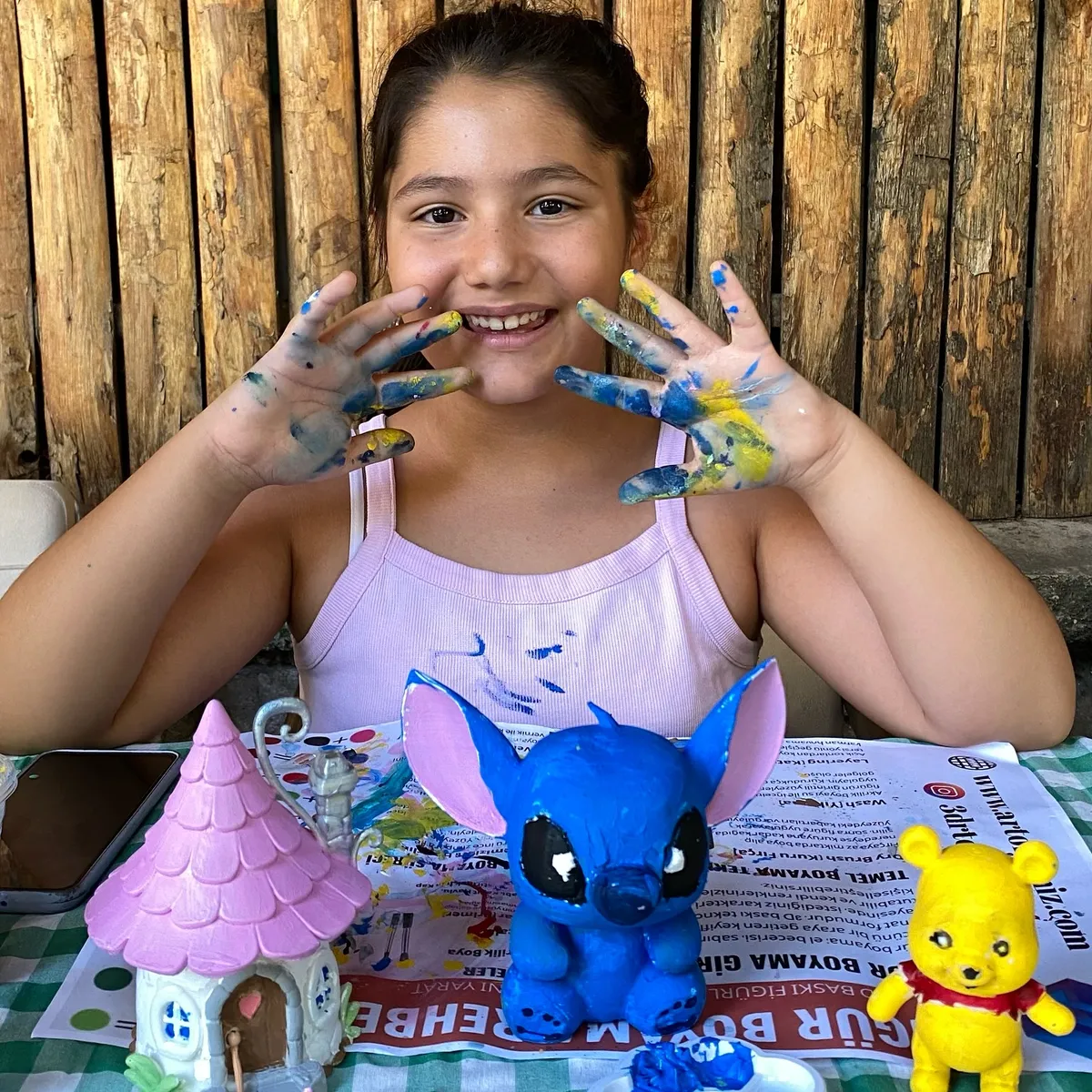 Boyanmış 3D baskı figürlerle poz veren çocuk